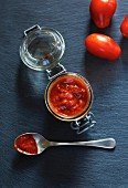 Selbstgemachtes Tomatenketchup auf Löffel und im Glas