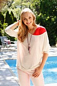 Junge blonde Frau in rotem Unterziehtop und Langarmshirt