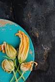 Courgette flowers on a blue wooden board