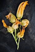 Courgette flowers on a black surface
