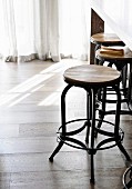 Bar stool in industrial style made of wood and metal on wooden floor