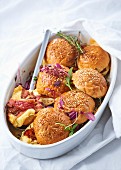 Gratinated sliders with Emmentaler cheese, bacon and rosemary in a baking dish