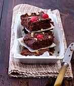 A stack of raspberry brownies with nuts