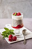 Chia pudding with raspberries and yoghurt in a dessert glass