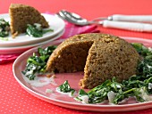 Almond nut roast on a bed of leaf spinach