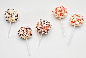 Popcorn balls on sticks decorated with colourful sugar sprinkles