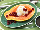Papaya filled with ice cream and served with redcurrants