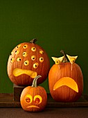 Drei Halloween-Kürbisse mit gruseligen Gesichtern