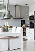 Weißer Esstisch und Stühle mit Hussen in der Küche