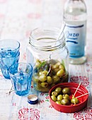 Olives with toothpicks and glasses of ouzo
