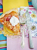 A slice of apricot tart with marzipan on a crystal plate