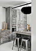 Concrete kitchen country and classic bar stools in front of rustic grey fitted kitchen