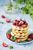 Fresh waffles with strawberries and icing sugar