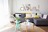 Stool and tray table in front of grey sofa with pastel scatter cushions