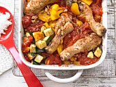 Oven-baked chicken legs in a tomato medley with courgettes and pepper