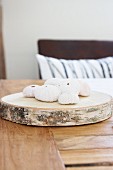 Sea urchin tests on slice of tree trunk on wooden table