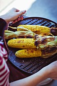 Grilled corn on the cob served on a barbecue griddle plate