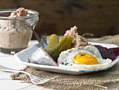 Labskaus (a traditional dish from Northern Germany) with soused herrings, fried egg and beetroot