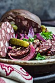 Sliced black pudding with gherkins and onions