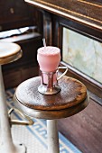 Strawberry milkshake on a barstool in a café