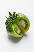 A green tomato on a white surface, sliced