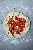 Unbaked tomato tart with ham (seen from above)