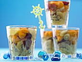 Fruit jelly with kiwi, grapes, physalis and pineapple in dessert glasses