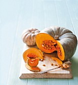 Two sliced pumpkins on a chopping board