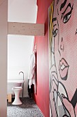 Ensuite bathroom with red wall, pebble floor and pop-art mural
