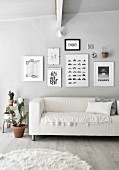 Sofa below gallery of pictures in monochrome living room