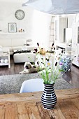 Black and white vase of wild flowers on rustic wooden table