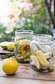 Pickled lemons in two jars on a wooden table