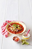Spicy bean soup with avocado, cheese and tortilla strips