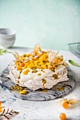 Pavlova with cream, mango, passion fruit and physalis