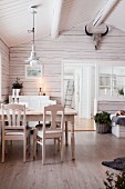 Dining table in wooden cabin with exposed roof structure