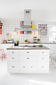 Kitchen island, retro scales and colourful tins in white fitted kitchen