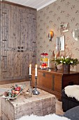 Fitted cupboard, wooden trunk and Advent arrangement in rustic living area