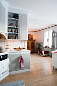 Country-house kitchen with view of cot and traditional long-case clock in living area