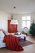 Skandinavisches Wohnzimmer mit Christbaum und roten Akzenten