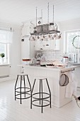 Island counter and bar stools in white country-house kitchen