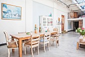 Vintage dining area on concrete floor and antique front door next to gallery