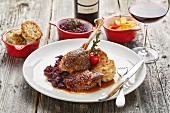 Roast goose with bread dumplings, red cabbage, pumpkin and a glass of red wine