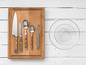 Kitchen utensils: knives, cutlery, a whisk and glass bowls