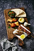 A Middle Eastern platter with kofta, tabbouleh, hummus and flatbread
