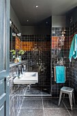 Black-tiled bathroom with shower area