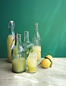 Zitronenlimonade in Glasflaschen und Glas