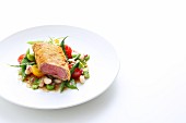 Saddle of lamb with a ciabatta coating served with a colourful bean salad