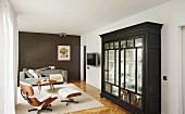 Glass-fronted cabinet, Eames Lounge Chair and sofa in elegant living area