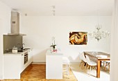Wooden table and Eames chairs in white designer kitchen with dining area