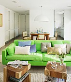Neon-green sofa and solid wooden side table in open-plan interior
